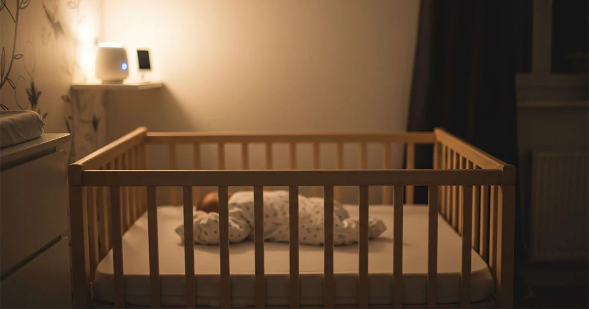 A soft, serene, and modern baby nursery bathed in gentle, warm ambient light.
